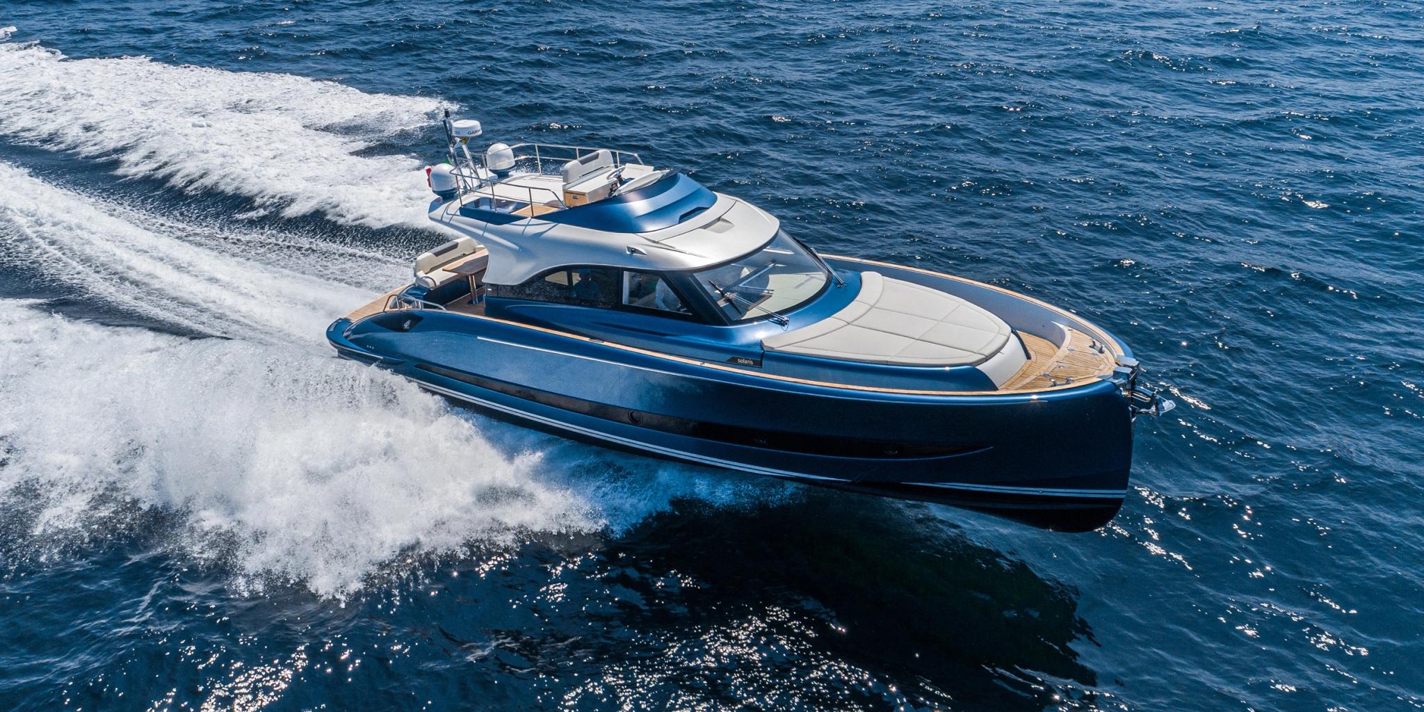 Yacht bleu et blanc d'un concessionnaire de bateaux neufs en Corse naviguant sur mer