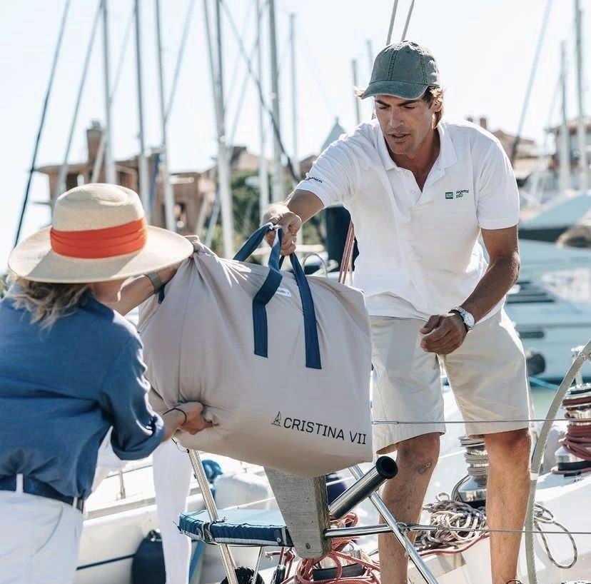 Homme et femme manipulant une voile de bateau dans un magasin nautisme en port