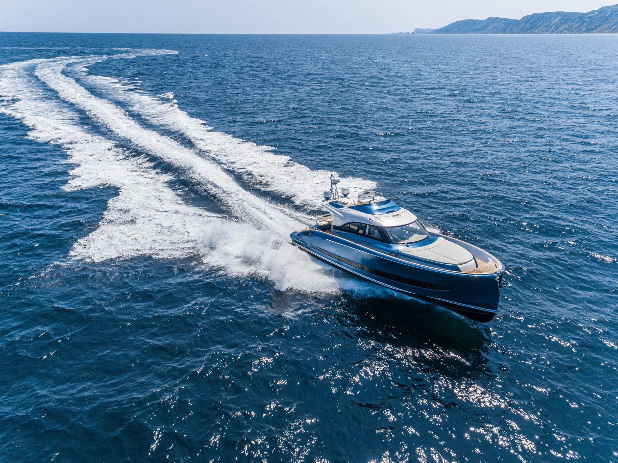 Yacht luxe bleu blanc navigant en Méditerranée avec sillage spectaculaire, concessionnaire bateaux neufs en Corse