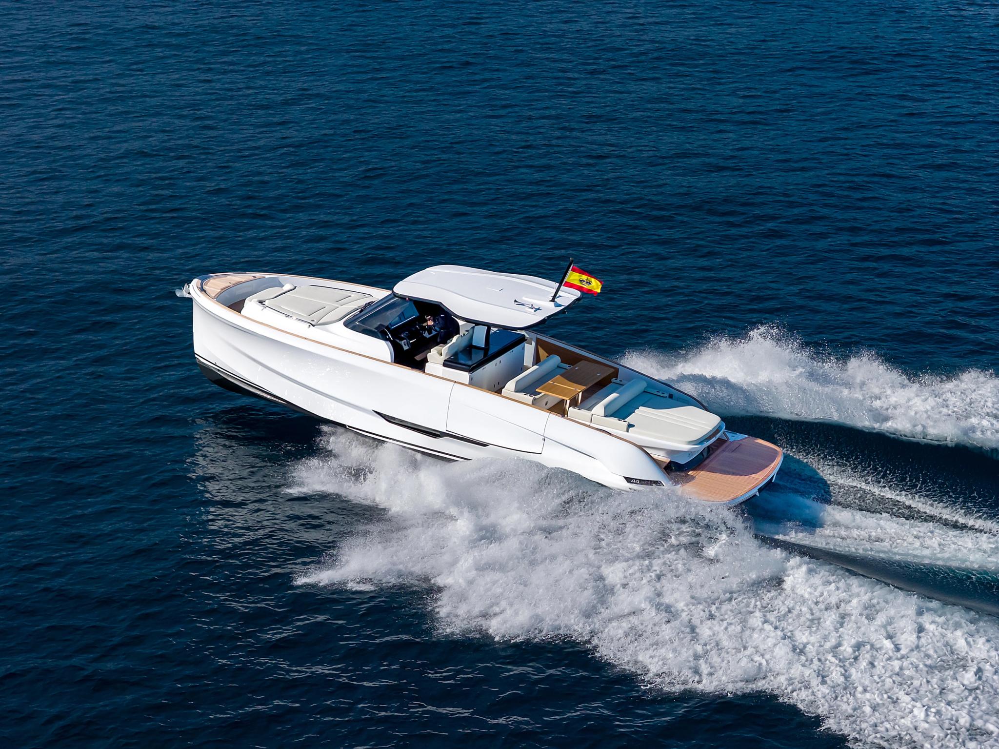 Bateau blanc neuf amarré près des vagues en Corse avec drapeau espagnol