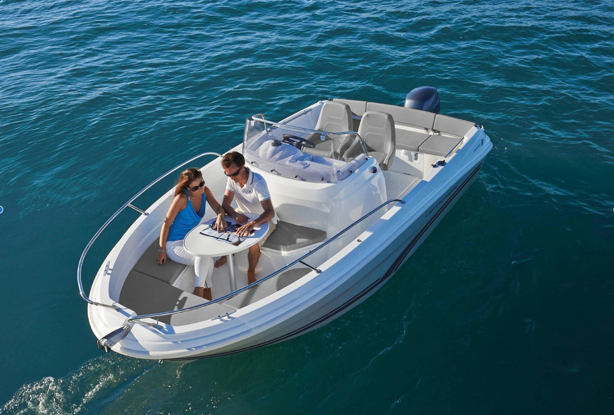 Couple admirant un bateau neuf blanc et bleu chez un concessionnaire bateaux en Corse