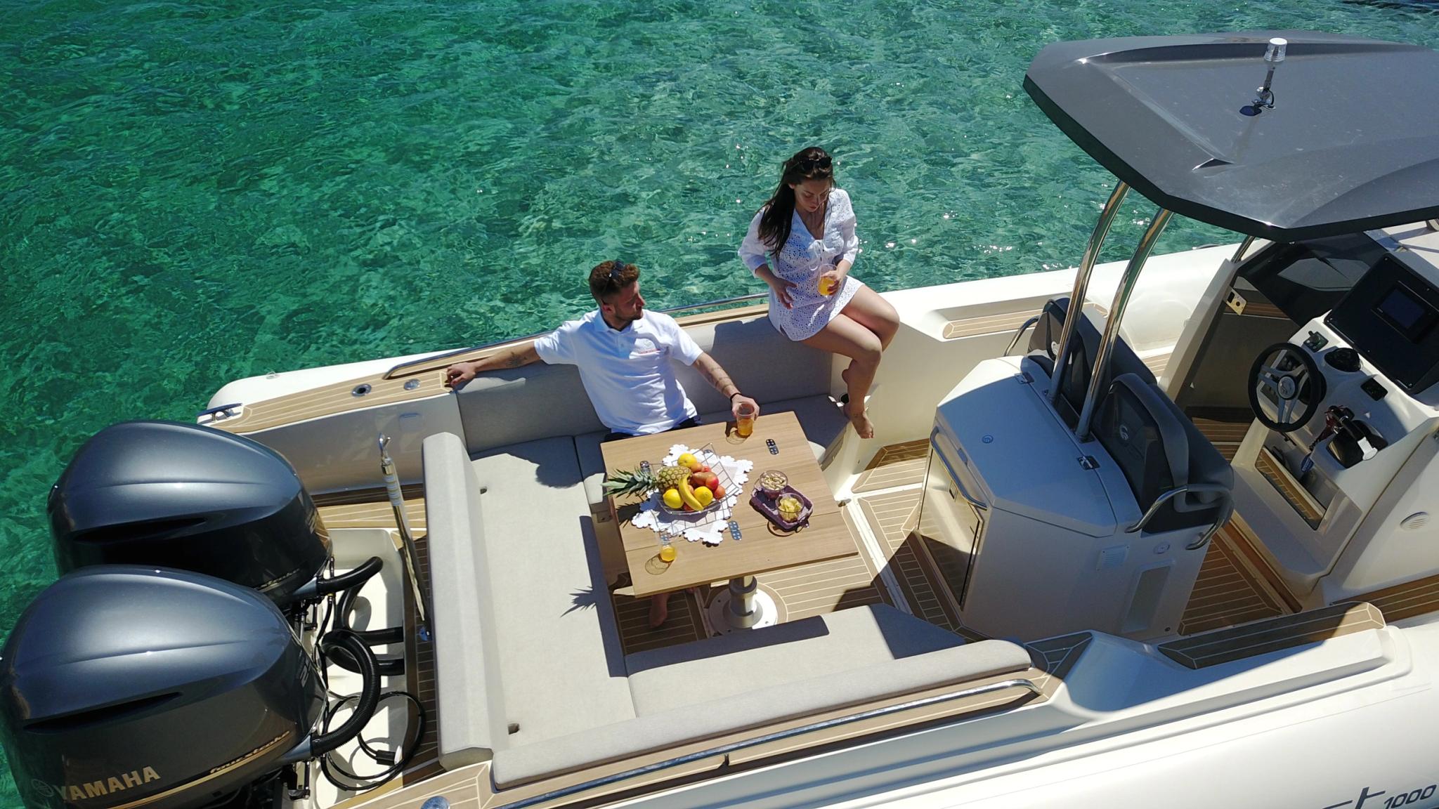 Couple profitant d'un bateau neuf chez un concessionnaire de bateaux en Corse en mer turquoise