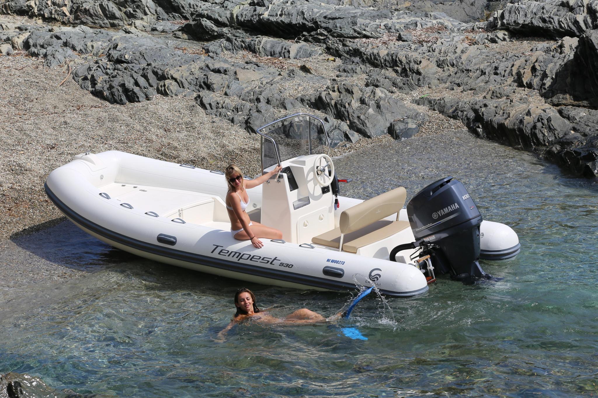 Concessionnaire de bateaux neufs en Corse avec bateau Tempest et personnes se baignant en mer
