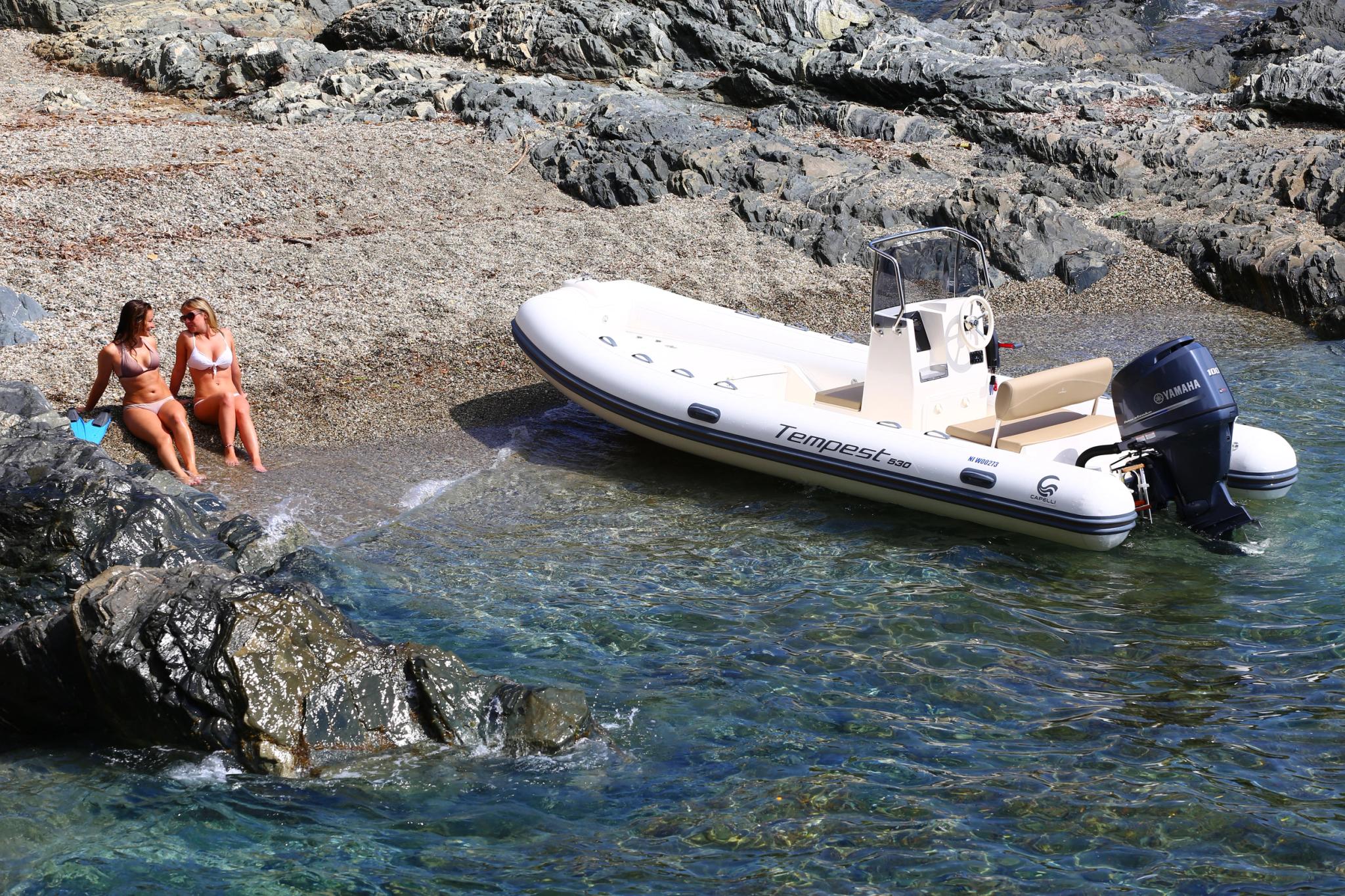 Bateau pneumatique Tempest amarré en Corse avec deux femmes à la baignade sur plage rocheuse