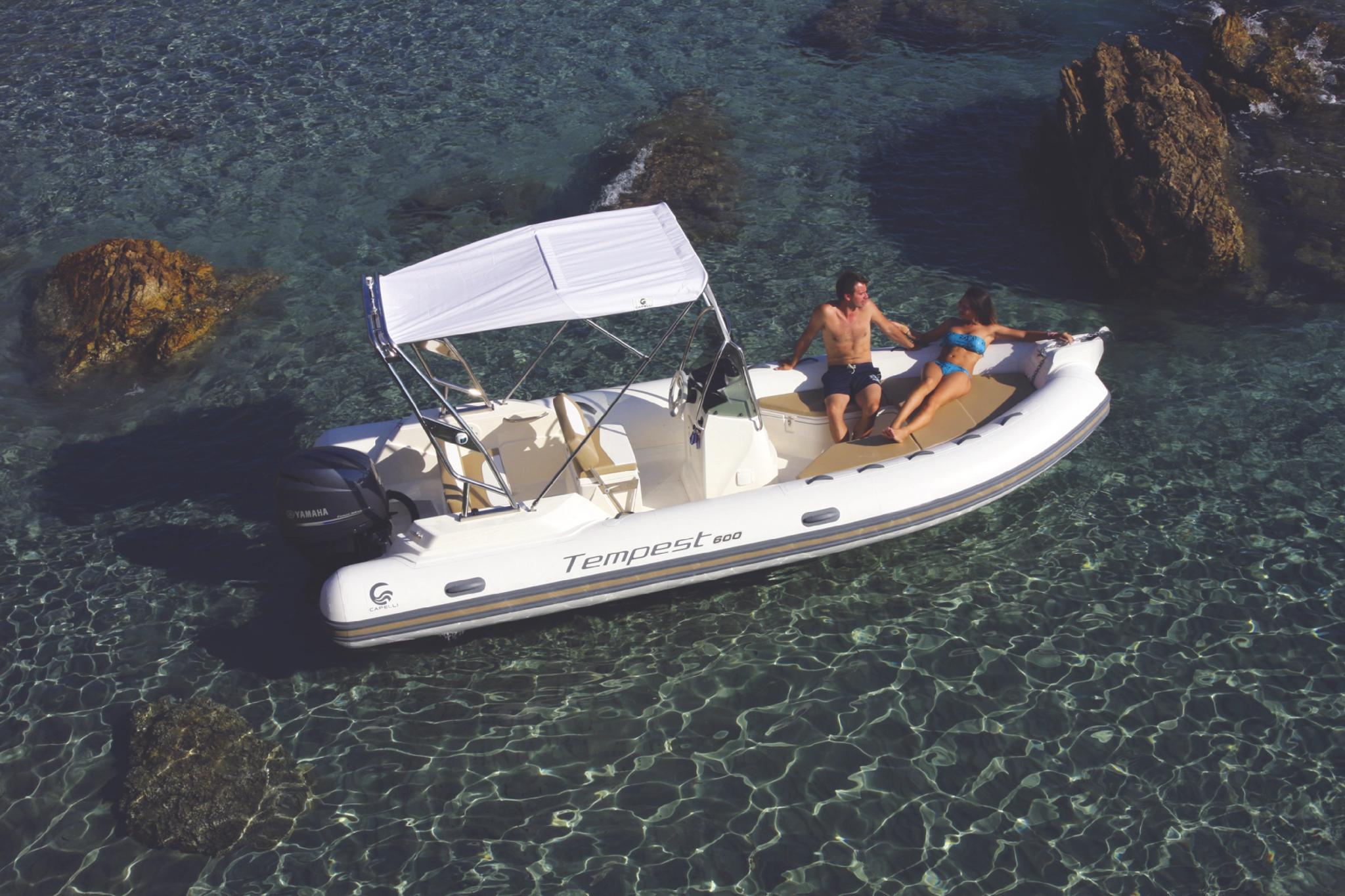 Bateau blanc Tempest amarré en Corse avec deux personnes à bord près des rochers