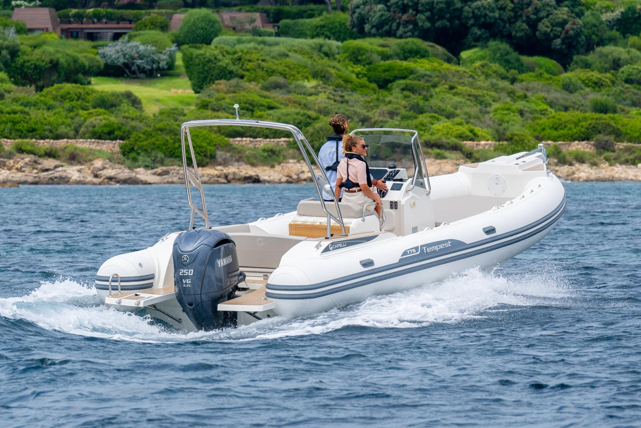 Bateau pneumatique blanc avec moteur naviguant en Corse près de la côte rocheuse