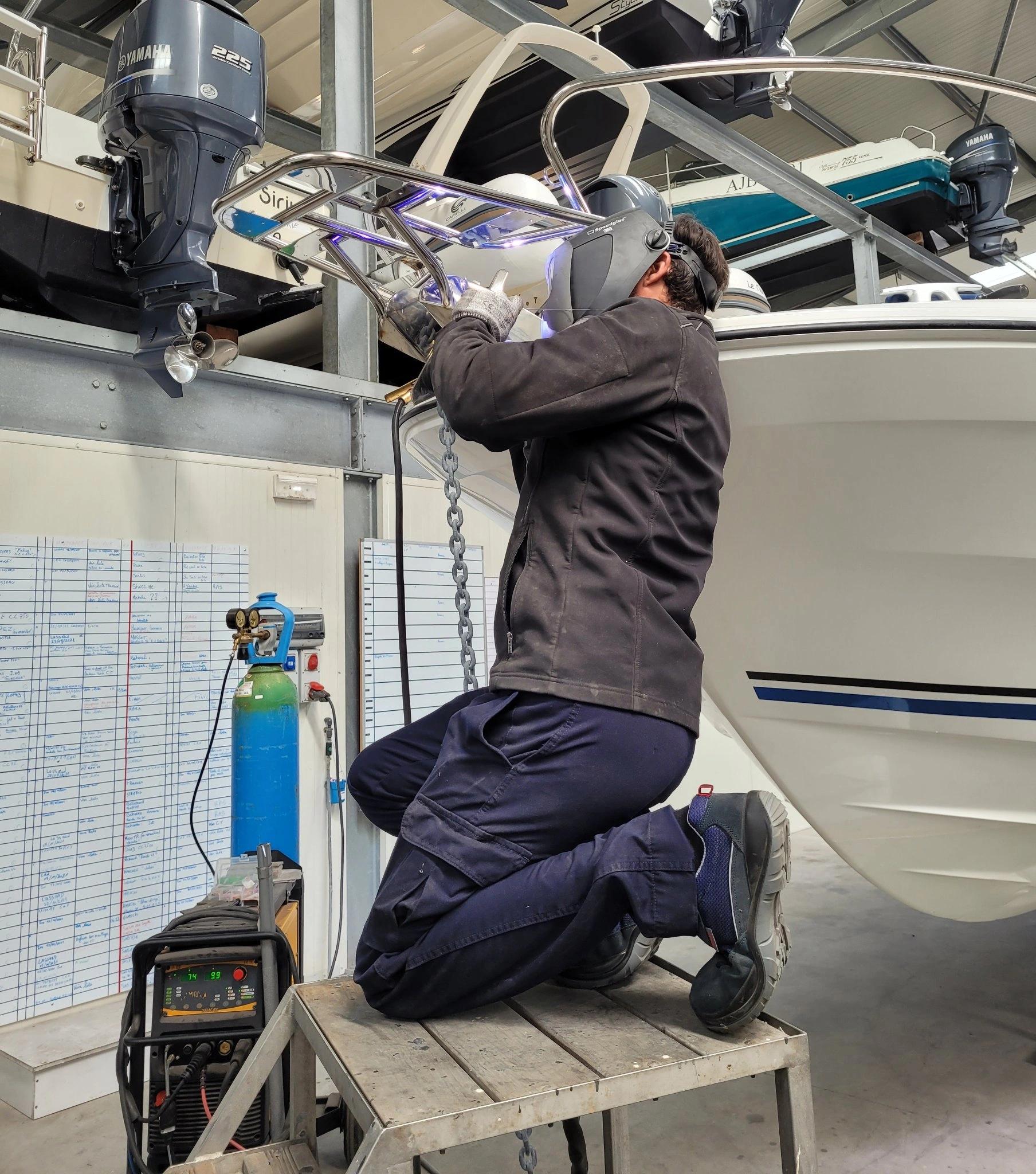 Technicien effectuant l'entretien et la réparation de bateaux en atelier