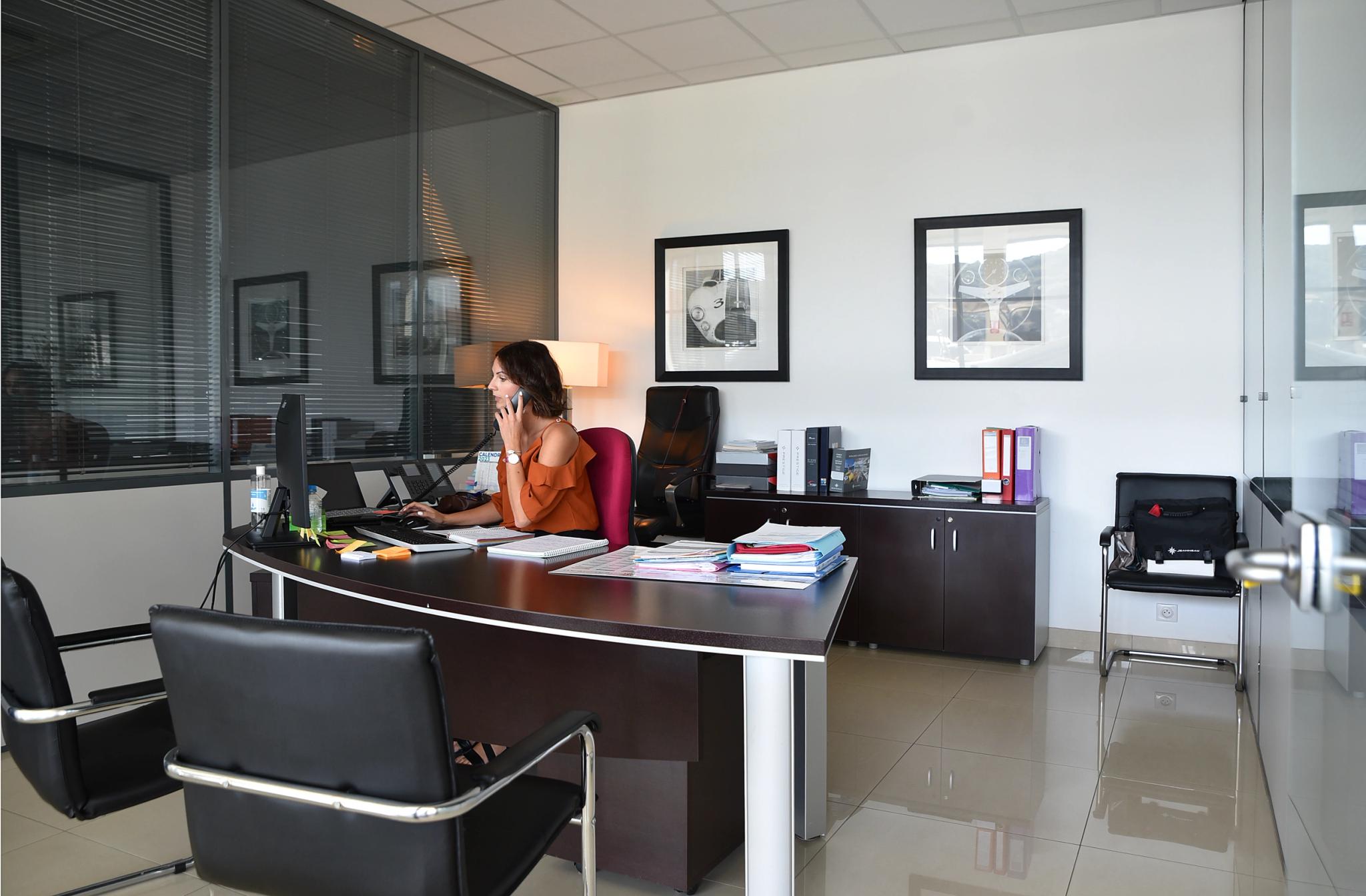 Je dois clarifier que l'image montre un bureau professionnel moderne avec une femme travaillant à son bureau, et non un ateli