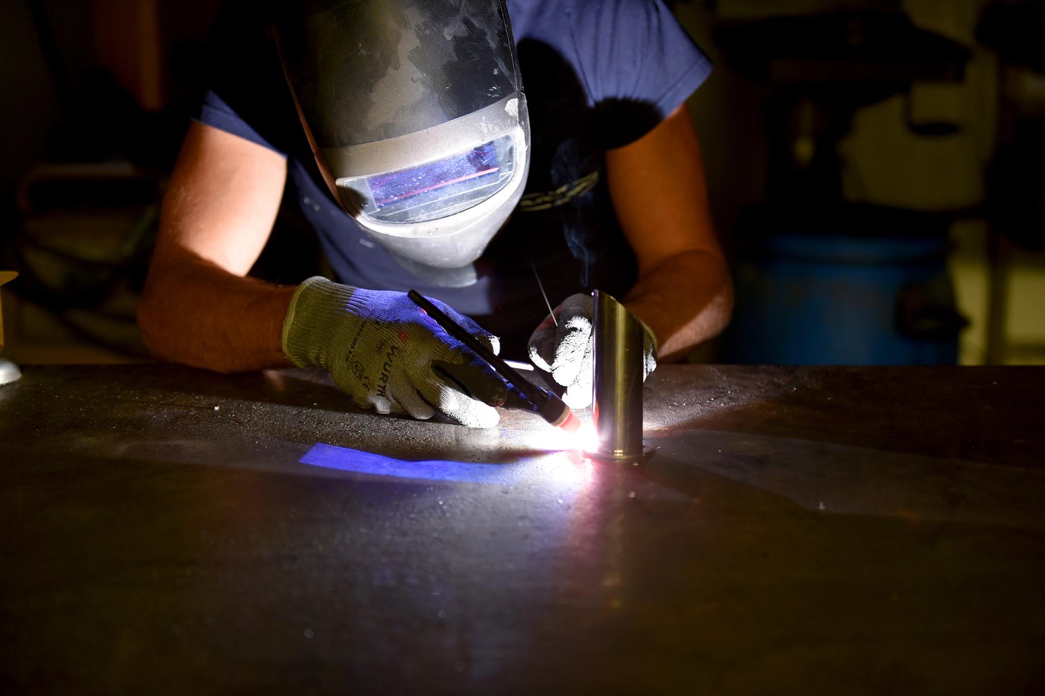 Soudeur professionnel utilisant services de soudage avec équipement de protection complet