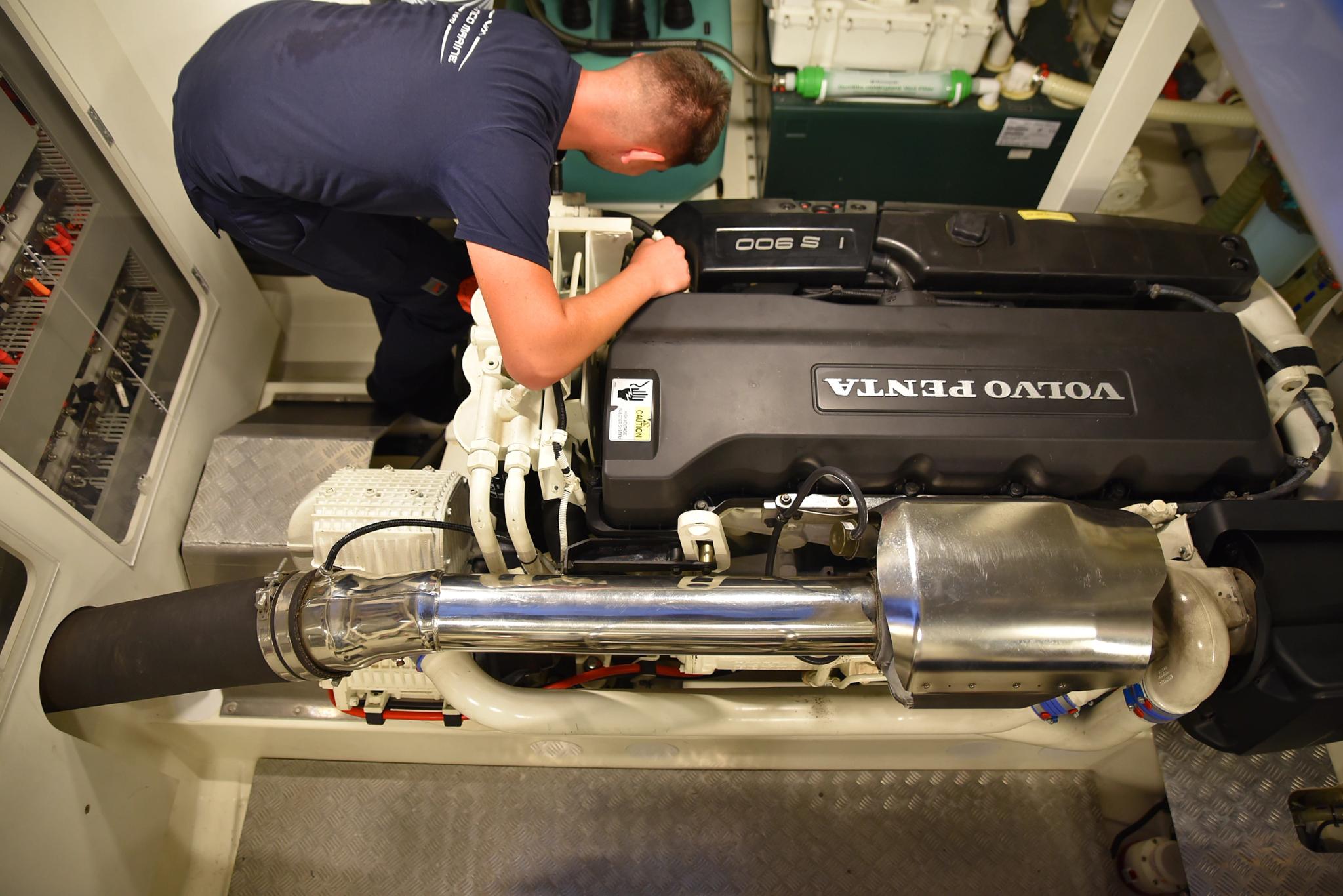 Technicien effectuant maintenance sur moteur et pièce détachée automobile